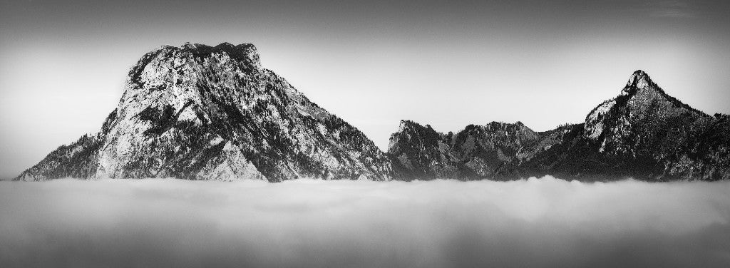 Sommet enneigé émergeant d’une mer de nuages